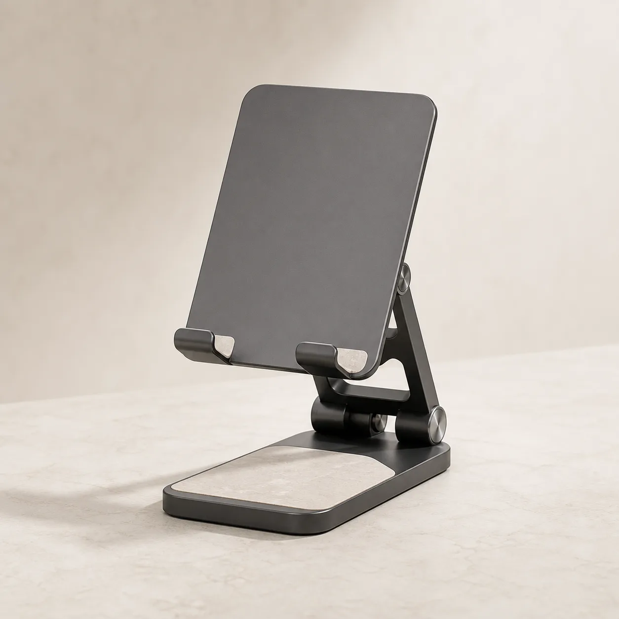 Matte graphite foldable desk stand on a pale stone surface.